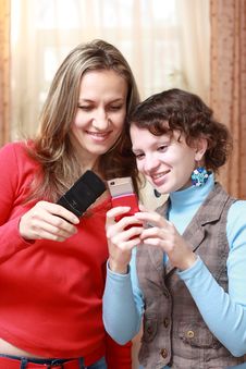 Two Girls With Mobile Phones Royalty Free Stock Photography