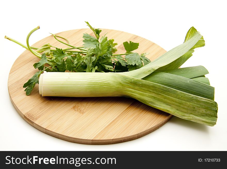 Leek and parsley on round wood plate