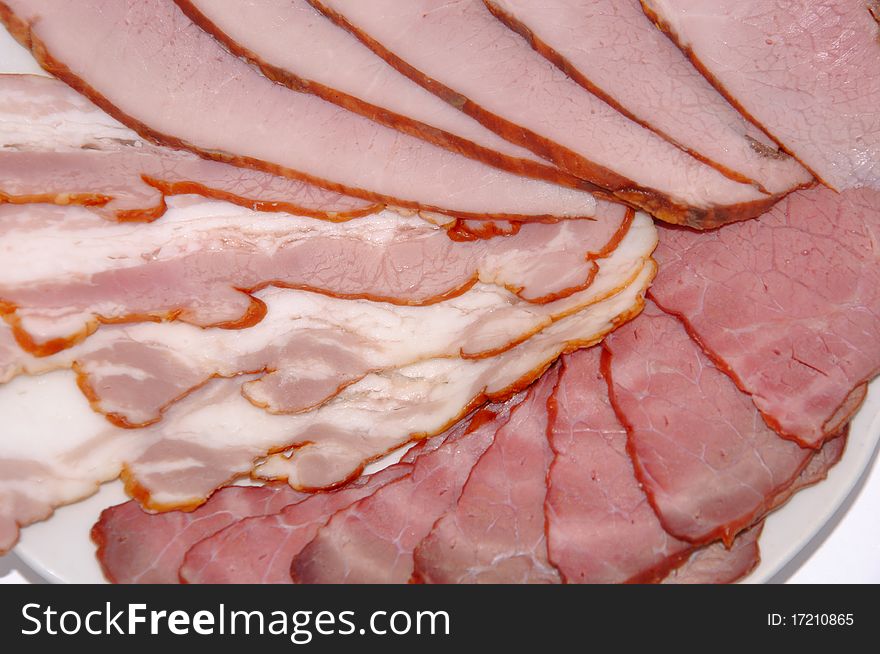 Meat cutting from a boiled pork and bacon on a white background