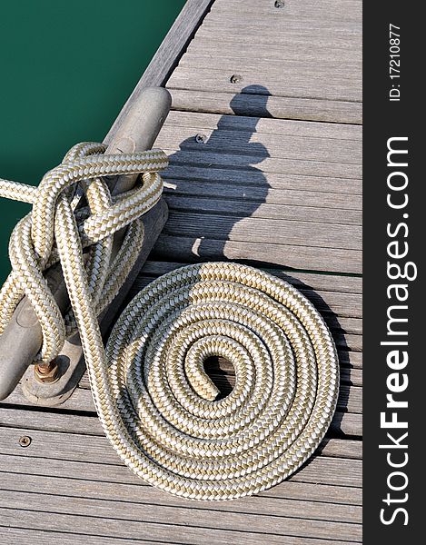 Rope of boat twist on dock board, as a circle, shown as maritime activities, sport or entertainment on sea. Rope of boat twist on dock board, as a circle, shown as maritime activities, sport or entertainment on sea.