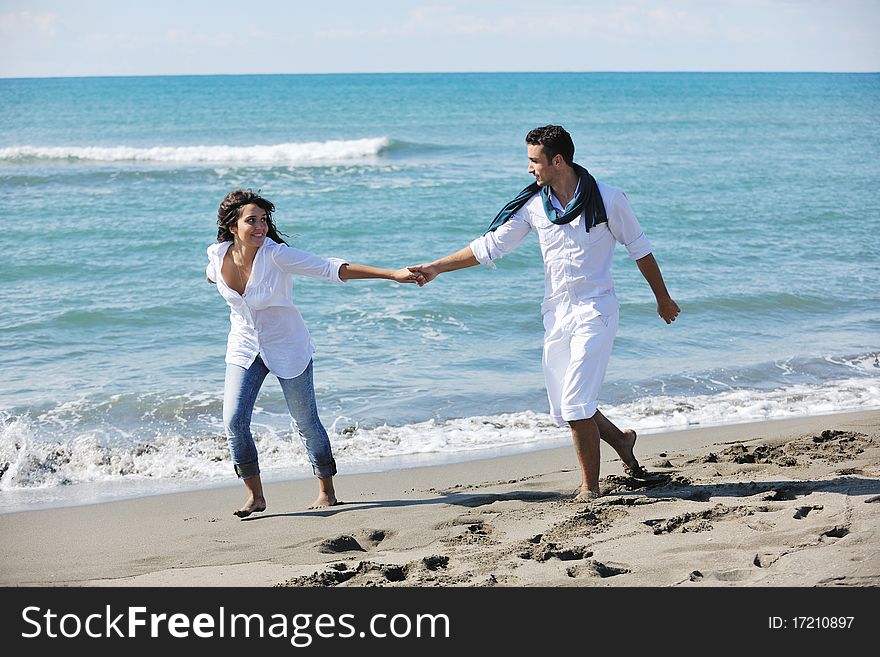 Happy young couple in white clothing have romantic recreation and fun at beautiful beach on vacations. Happy young couple in white clothing have romantic recreation and fun at beautiful beach on vacations