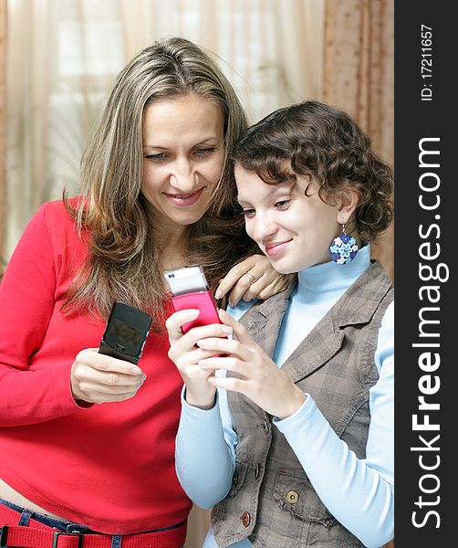 Two girls with mobile phones at home