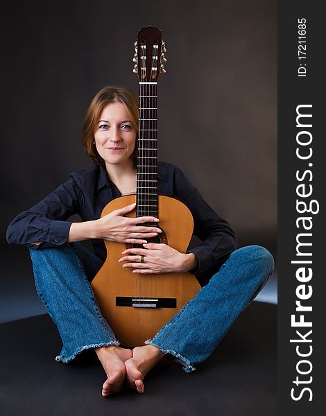 Portrait of the girl with a guitar on a black background. Portrait of the girl with a guitar on a black background