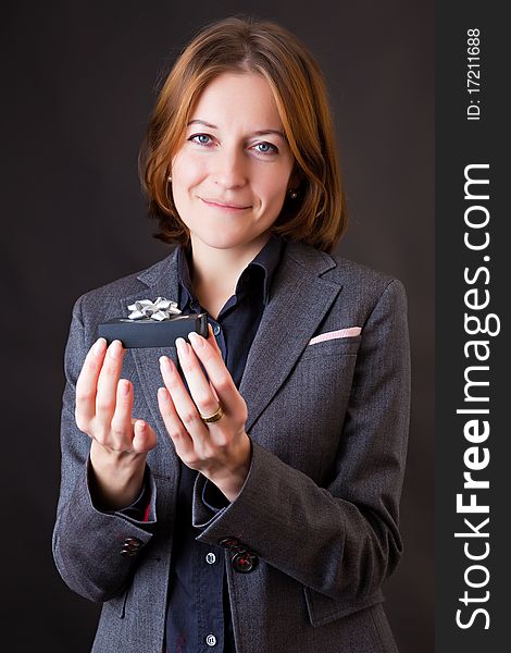 Girl in a business suit with a gift in a hands. Girl in a business suit with a gift in a hands
