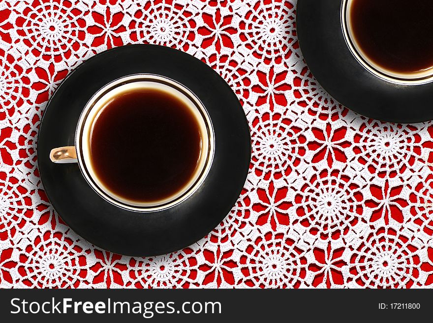 Two coffee cups on lace tablecloth