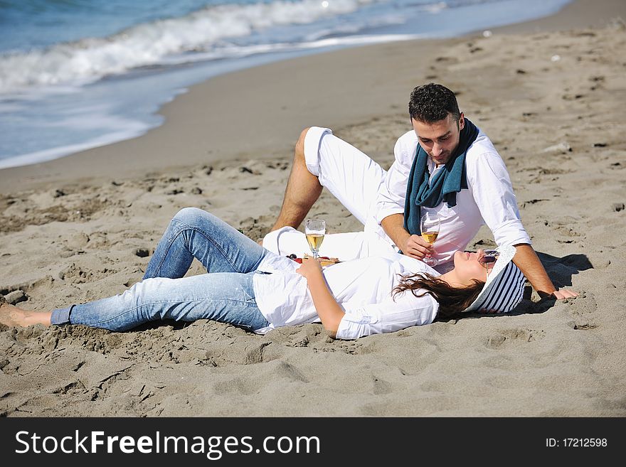Happy young couple enjoying  picnic on the beach and have good time on summer vacations