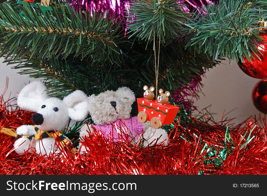 Tinsel, soft toys, balls and other trinkets under the christmas fir tree. Tinsel, soft toys, balls and other trinkets under the christmas fir tree.