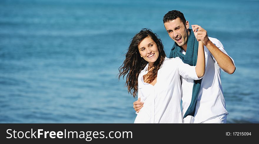 Happy young couple in white clothing have romantic recreation and fun at beautiful beach on vacations. Happy young couple in white clothing have romantic recreation and fun at beautiful beach on vacations