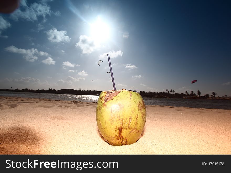 Coconut cocktail on beach sand