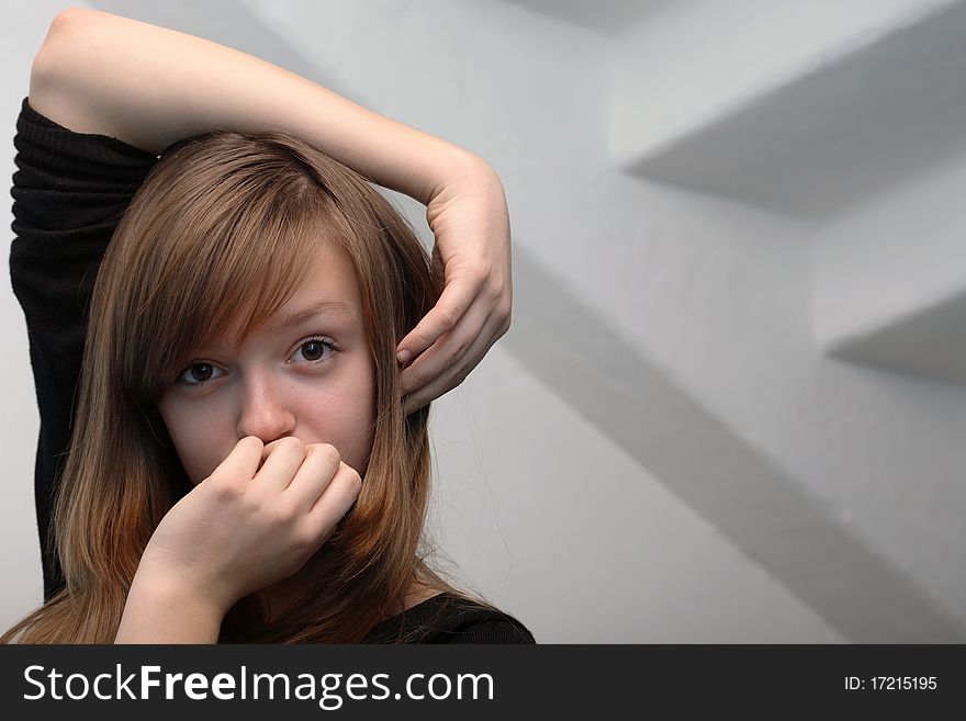 Nice young girl portrait on gray background with staircase