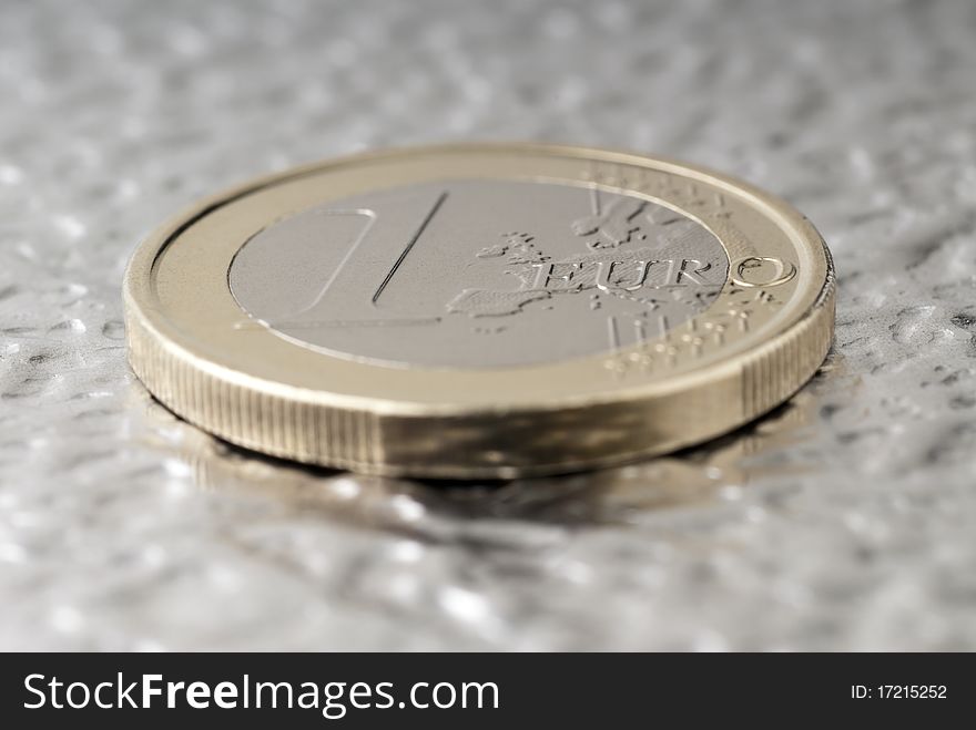 A one euro coin on a flat metal. A one euro coin on a flat metal