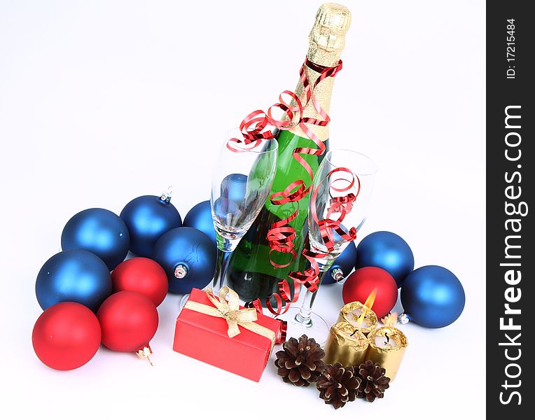 Christmas and New Year's theme -  a bottle of champagne, glasses, candles, a gift, and cones on white backgrond