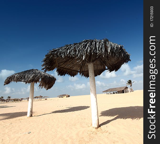 Umbrella in desert under blue sky