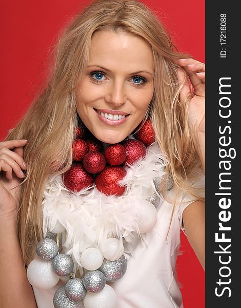 Beautiful blond woman with some feathers and christmas balls around her neck. Beautiful blond woman with some feathers and christmas balls around her neck