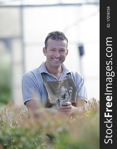 Smiling gardener in a greenhouse