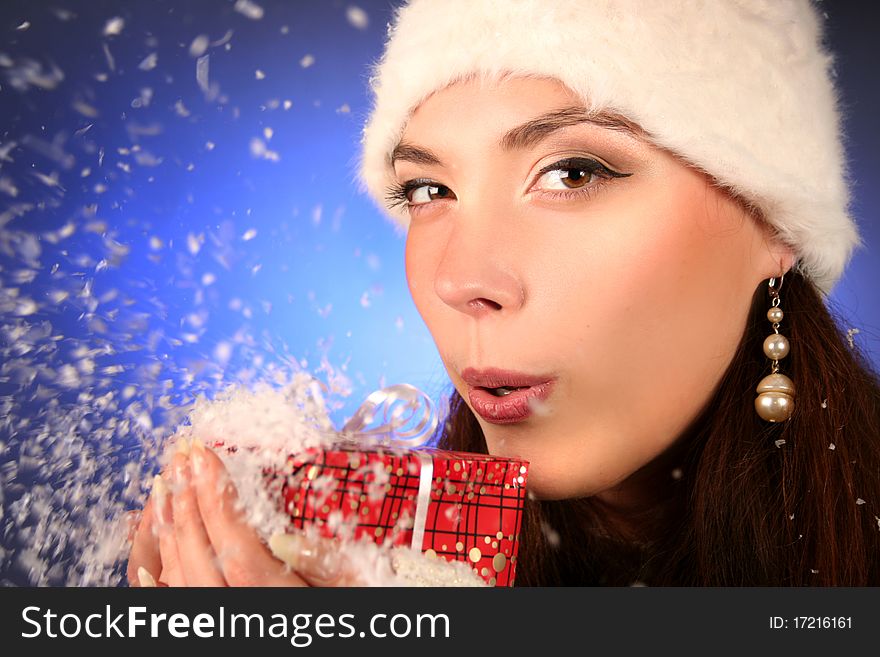 Cute young woman blows snowflakes. Cute young woman blows snowflakes