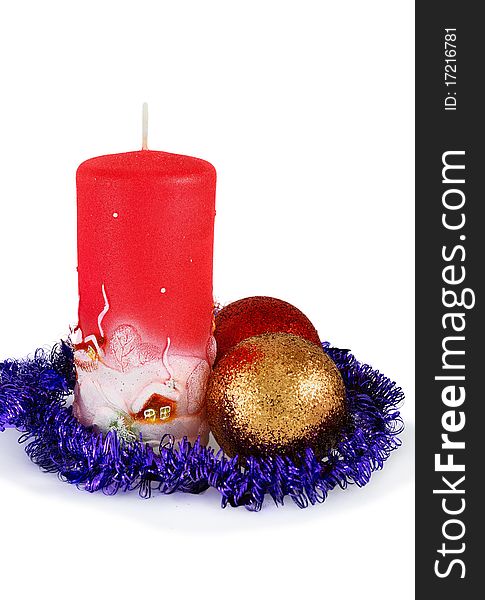 Decorative christmas candle of red color with the image of rural small houses and two christmas balls with light shadow. Isolated on white. Decorative christmas candle of red color with the image of rural small houses and two christmas balls with light shadow. Isolated on white.