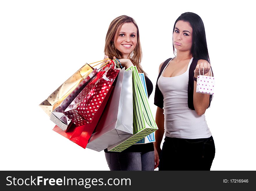 Two girls holding shopping bags, one happy and the other disappointed, on a white background. Two girls holding shopping bags, one happy and the other disappointed, on a white background.