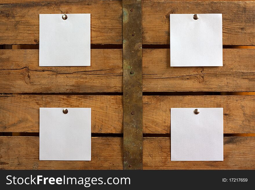 Four pieces of blank paper tacked to wooden background.Ready for your text