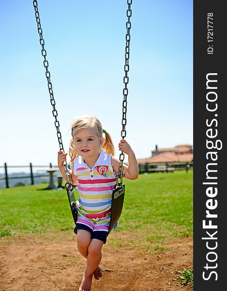 Young child on swing in playground outdoors