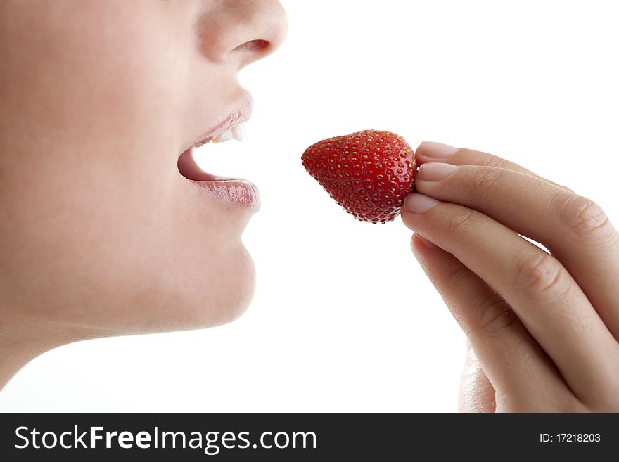 Beautiful young woman eating a fresh strawberry. Beautiful young woman eating a fresh strawberry