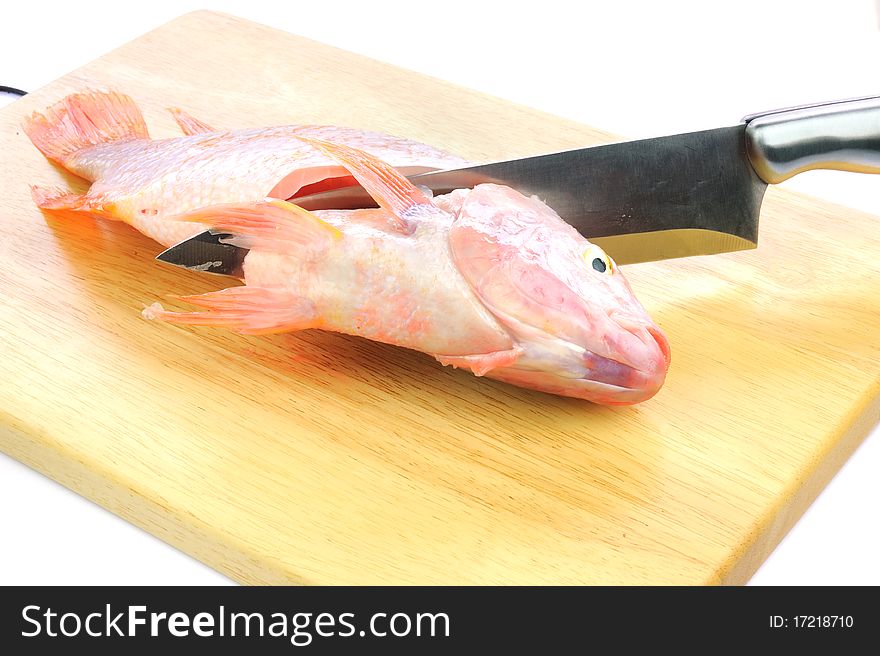 Red tilapia on wood chopping block .