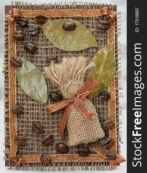 Handmade Card. Sack from coffee, a bay leaf and coffee grains on a sacking.