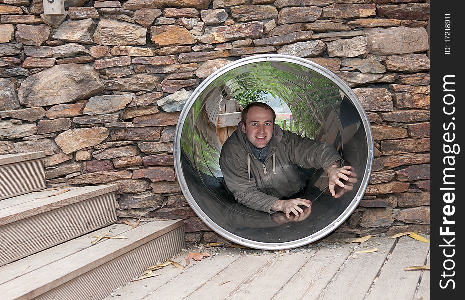 Lad creeps on steel pipe in stone wall