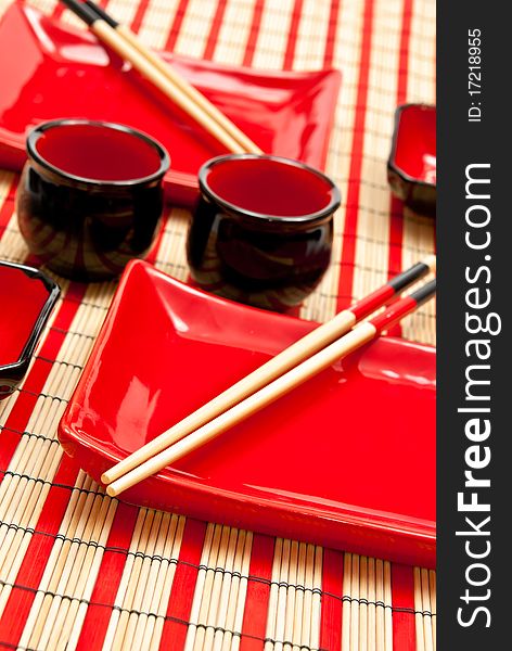 Red and black empty sushi set on the bamboo background