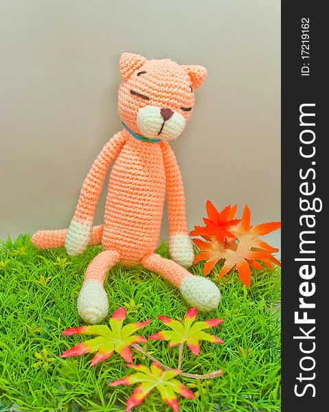 Knitted cat toy isolated on green grass