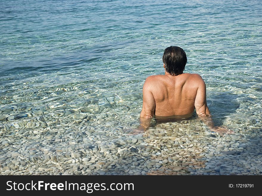 Man sitting in the sea and relaxing during his vacation. Man sitting in the sea and relaxing during his vacation.