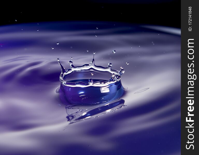 A water splash in purple tone with black background