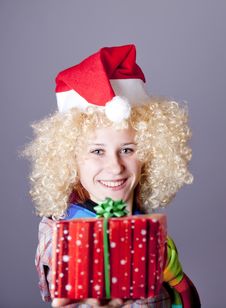 Girl In Blonde Wig And Christmas Hat Show Gift. Stock Image Girl In Blonde Wig And Christmas Hat Show Gift. Stock Image