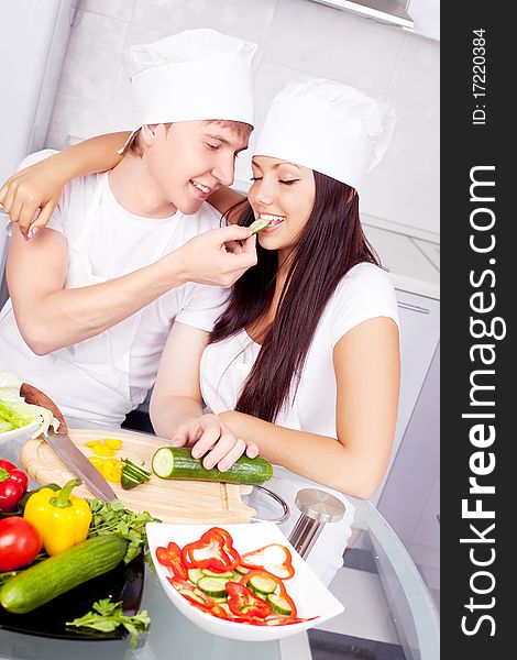 Two happy young cooks making salad in the kitchen. Two happy young cooks making salad in the kitchen