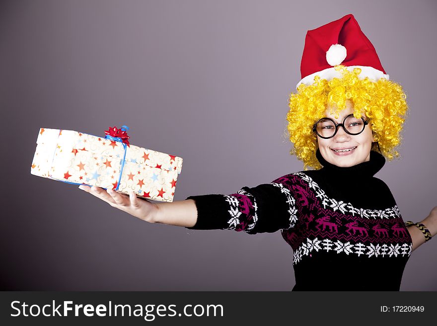 Funny girl in glasses with christmas gifts. Studio shot.