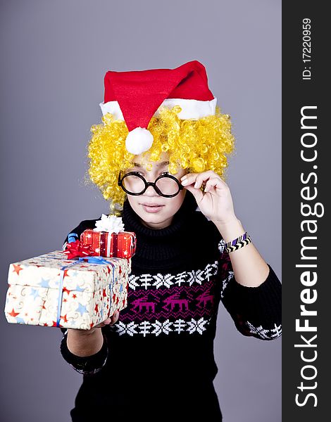 Funny girl in glasses with christmas gifts. Studio shot.