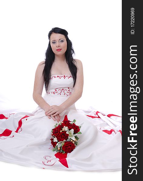 Photograph showing cute young bride in white and red wedding dress isolated against white