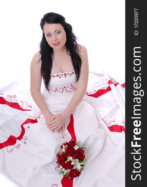 Photograph showing cute young bride in white and red wedding dress isolated against white