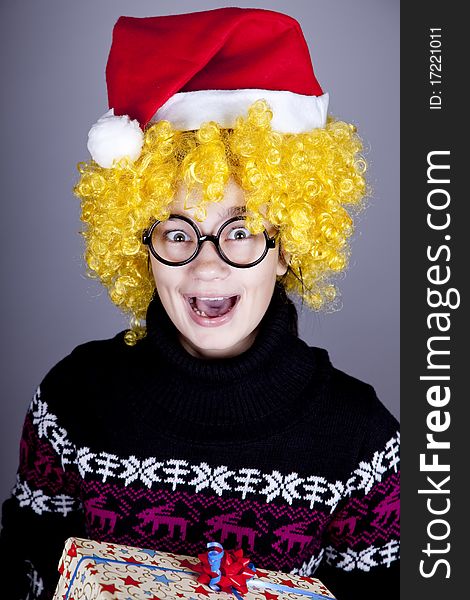 Funny girl in glasses with christmas gifts. Studio shot.