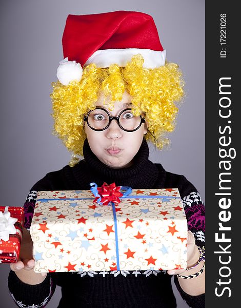 Funny girl in glasses with christmas gifts. Studio shot.