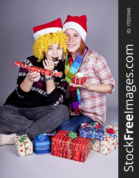 Two funny girls with christmas gifts. Studio shot.