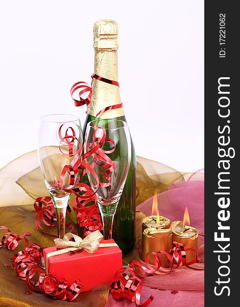 Bottle of champagne, glasses, candles and a gift. Bottle of champagne, glasses, candles and a gift