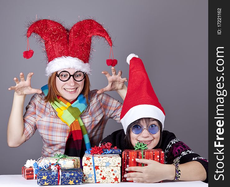 Two funny girls with christmas gifts. Studio shot.