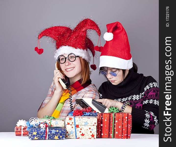 Two girls calling to Santa for better christmas gift. Studio shot.
