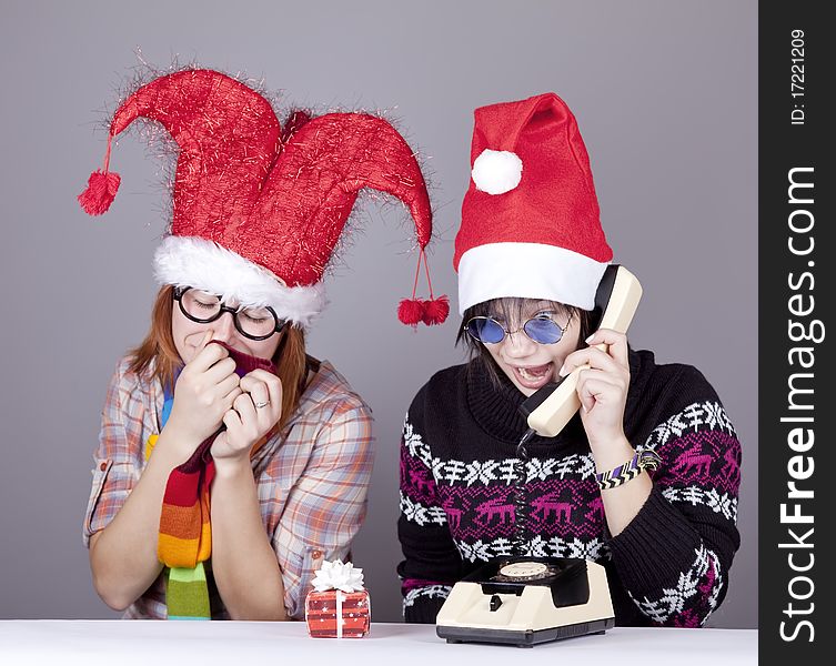 Two girls calling to Santa for better christmas gift. Studio shot.