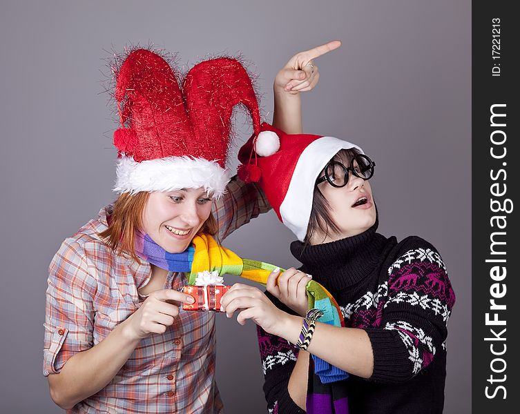 Two funny girls with christmas gifts. Studio shot.