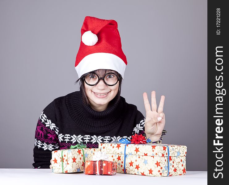 Funny girl in glasses with christmas gifts. Studio shot.