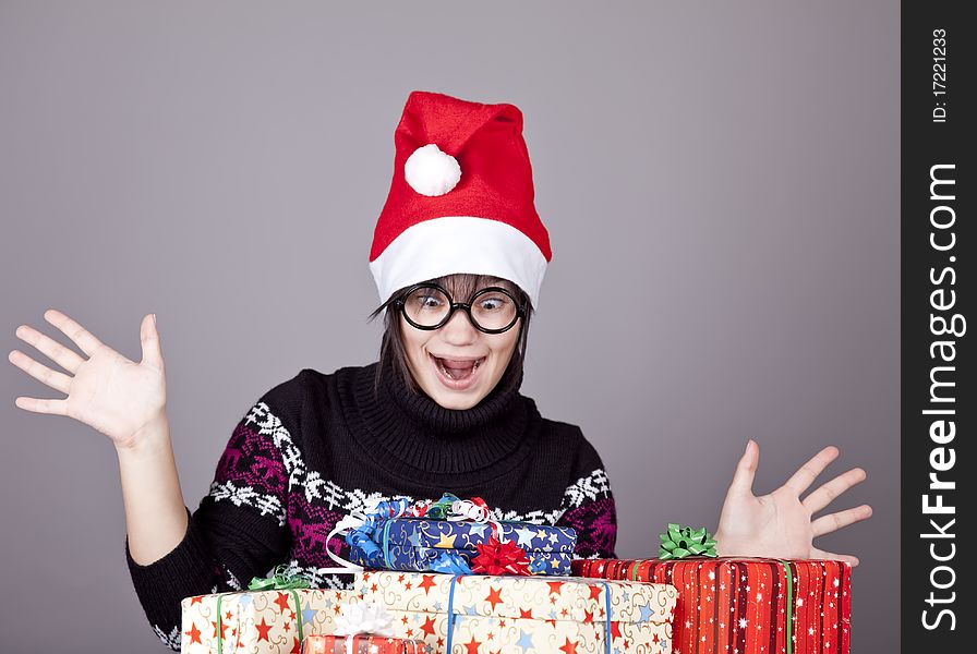 Funny girl in glasses with christmas gifts. Studio shot.