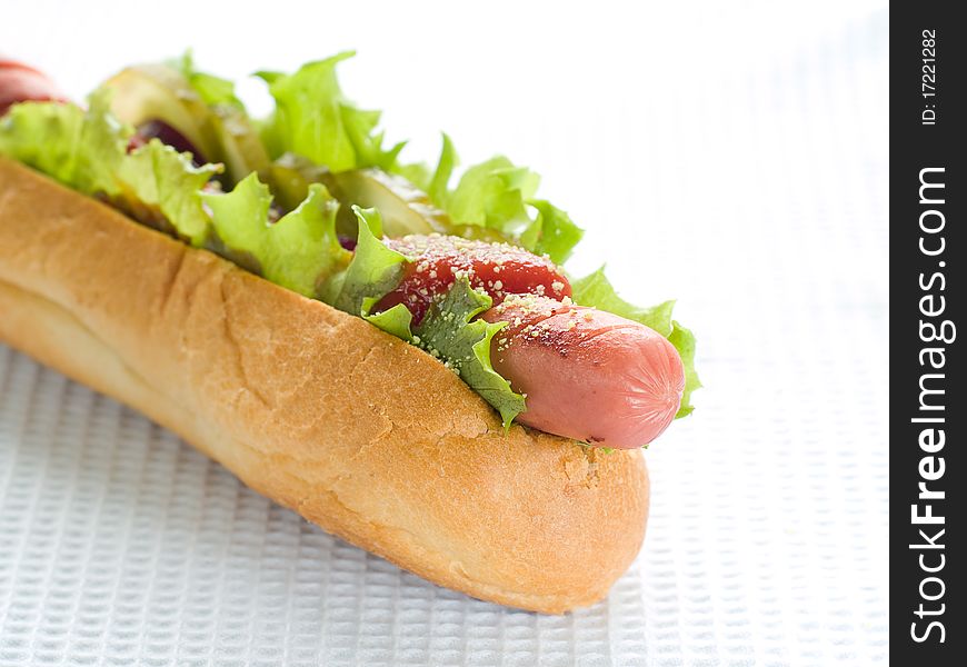 Hot Dog with ketchup, sausage, onions, lettuce and salted cucumber