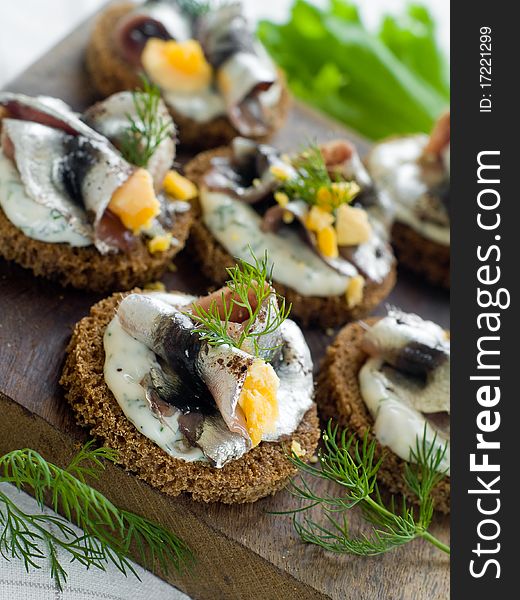 Anchovy canapes garnished with dill and yolk